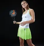 Spielerin stehend haelt Royal Padel 130 Factor 2026 Padelschlaeger in weissem Outfit
