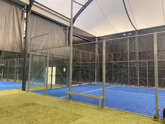 MS Manza Indoor-Padelplatz mit Sicherheitsabsperrung und Sitzbank am Eingang