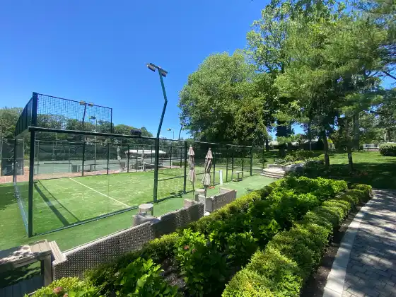 MS Miami Padelplatz in Clubanlage mit grünem Court neben Tennisplatz und Parkkulisse