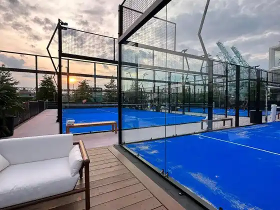 MS Miami Padelplatz auf Rooftop bei Sonnenuntergang mit Hafenkulisse und Lounge-Bereich