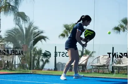 Spielerin mit Padel Schläger beim Padel allein trainieren auf dem Court in Schlagvorbereitung