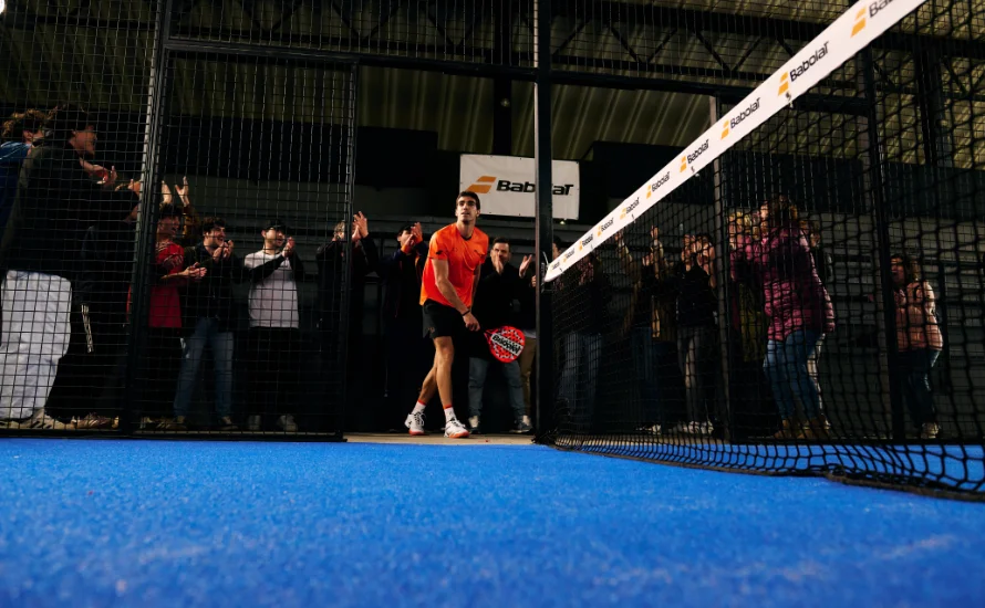 Juan Lebrón im orangen Trikot betritt einen Indoor-Court bei einem Turnier während Zuschauer applaudieren