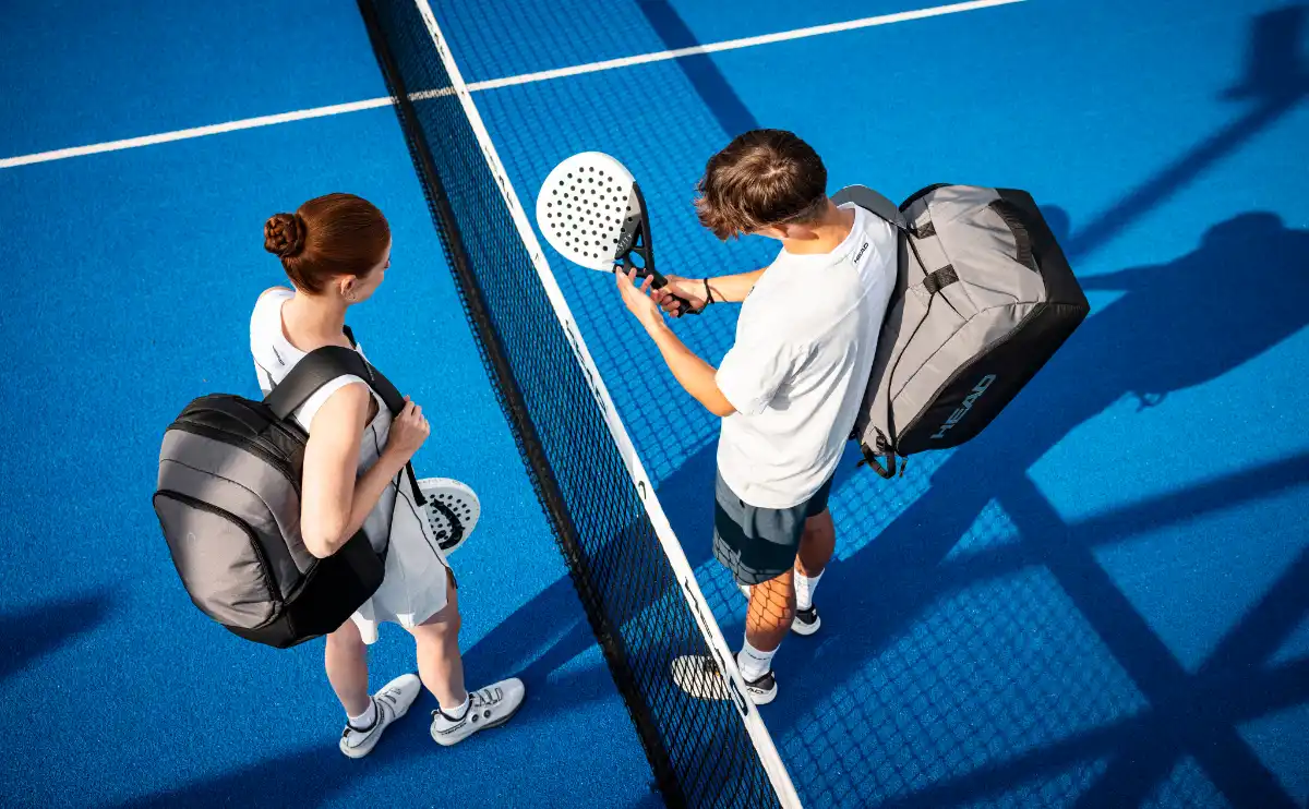 Zwei Padel-Spieler beim Padel Trainingsplan auf dem Court mit Padeltaschen und Schläger