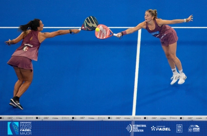 Zwei Profi-Spielerinnen strecken sich zeitgleich nach dem Ball am Netz beim Greenweez Paris Premier Padel Major