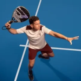 Paquito Navarro schlaegt dynamisch einen Padelball mit dem Bullpadel Hack 04 auf einem blauen Padelcourt - Bullpadel Markenbotschafter bei Padel4Players